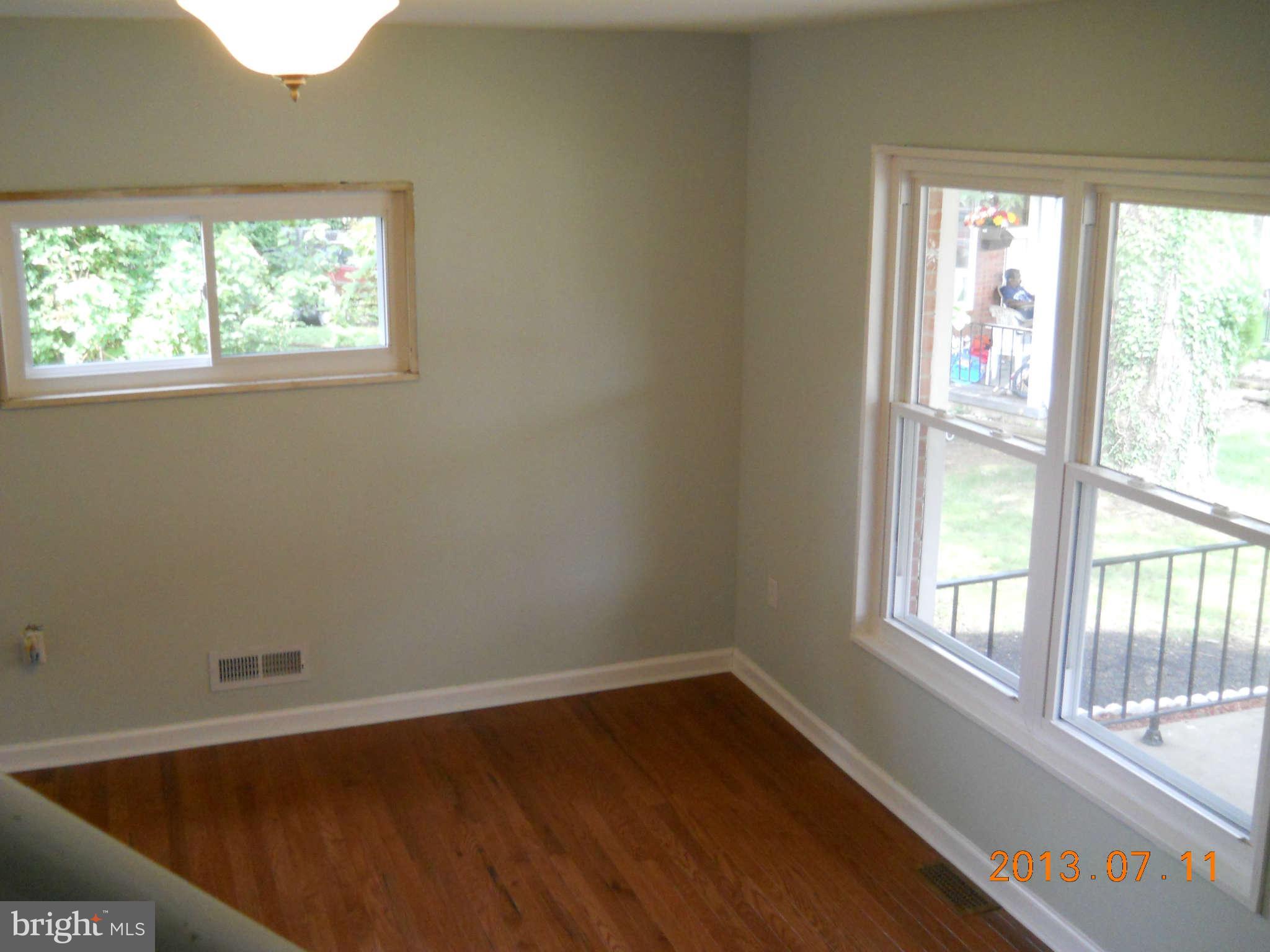 500 Queensgate Road Baltimore, MD 21229 - Photo 4 of 14 a view of an empty room with wooden floor and a window