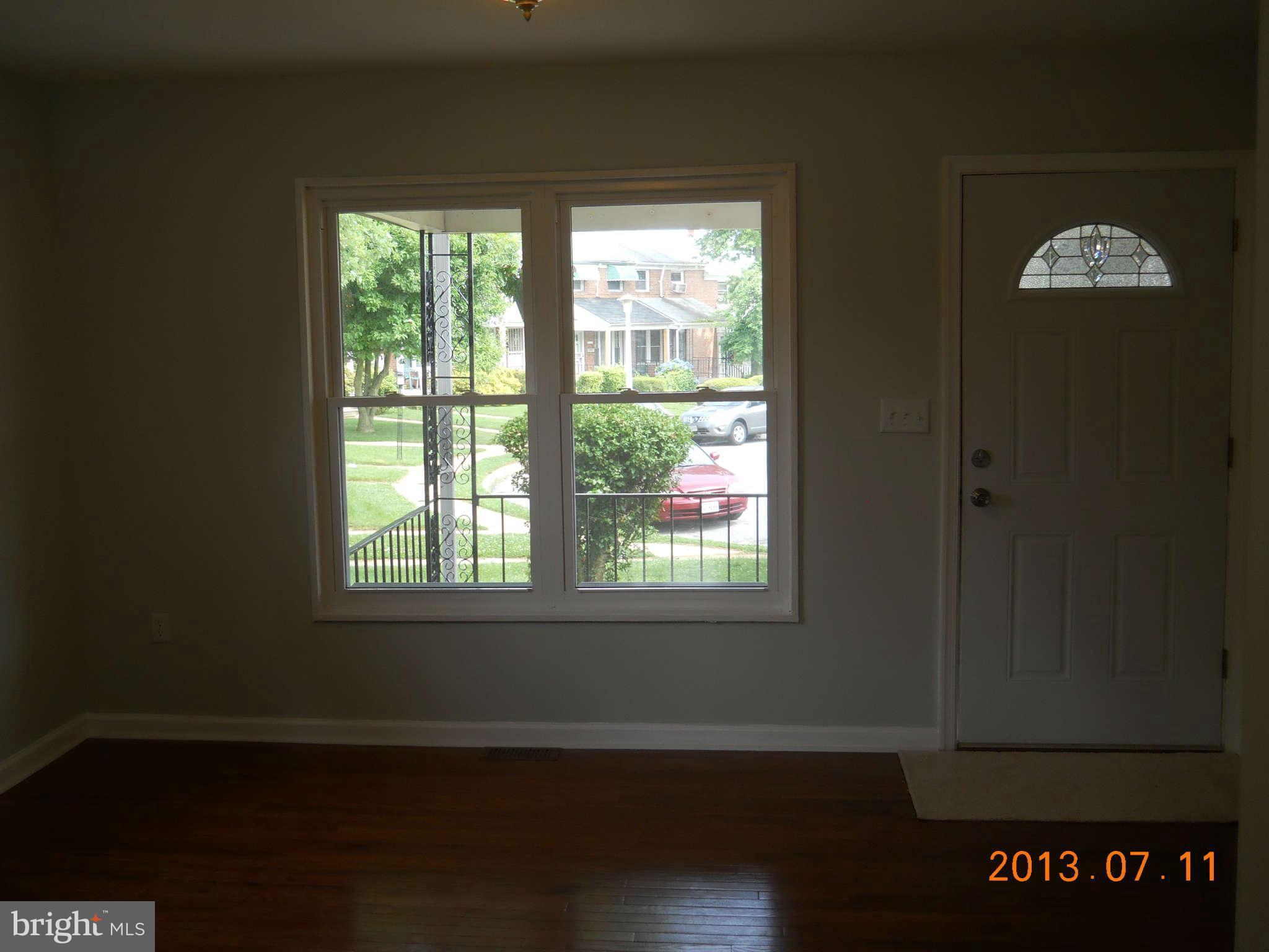 500 Queensgate Road Baltimore, MD 21229 - Photo 5 of 14 a view of an empty room with wooden floor and a window