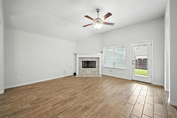 a view of an empty room with a fireplace and a window