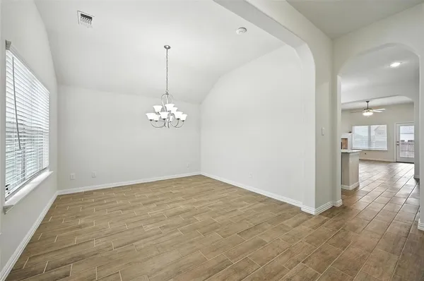 a view of a chandelier in an empty room with a window