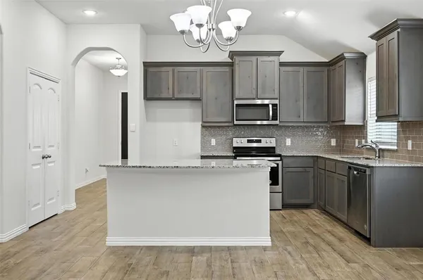a kitchen with cabinets a sink and appliances