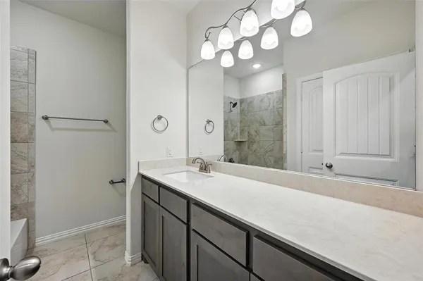 a bathroom with a sink a light fixture and a mirror