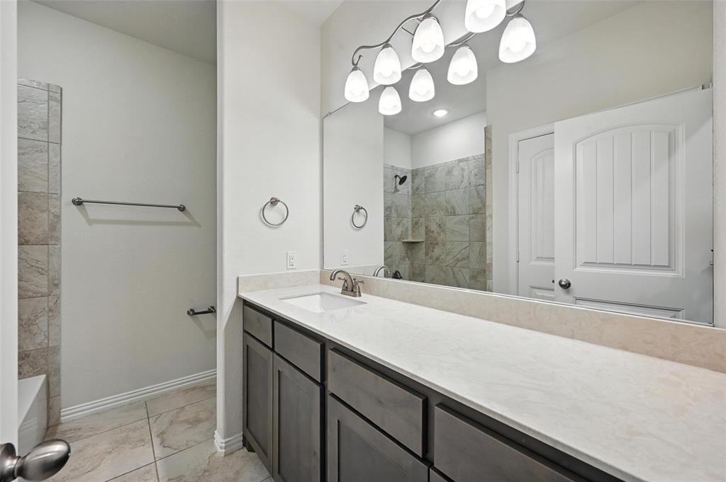 5 Pheasant Run Sanger, TX 76266 - Photo 10 of 27 a bathroom with a sink a light fixture and a mirror