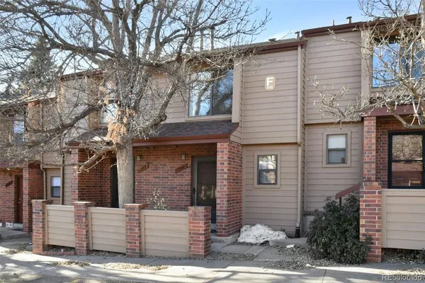 a front view of a house with a tree