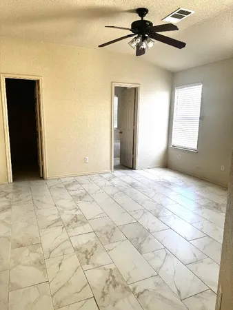 a view of a livingroom with a ceiling fan and window