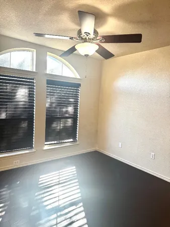 a view of a room with a ceiling fan and window