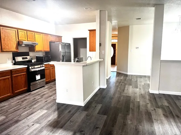 a kitchen with stainless steel appliances wooden floors and large window