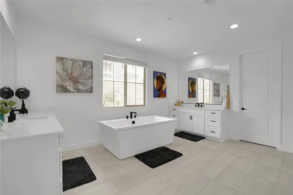 a spacious bathroom with a double vanity sink a mirror and a bathtub