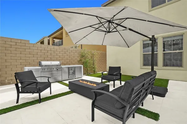 a view of a patio with a table and chairs under an umbrella