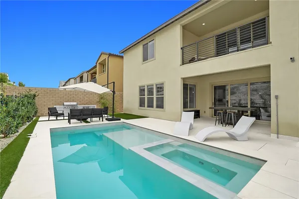 a view of a house with swimming pool and sitting area