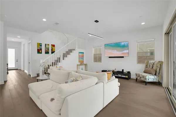 a living room with furniture and a wooden floor