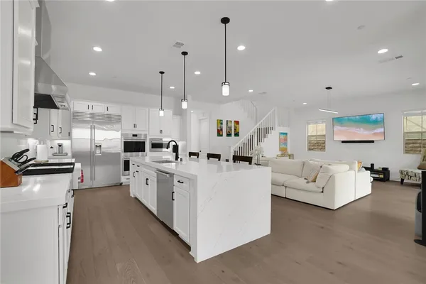 a large white kitchen with stainless steel appliances