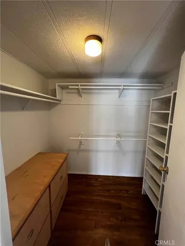 a view of walk in closet with empty racks