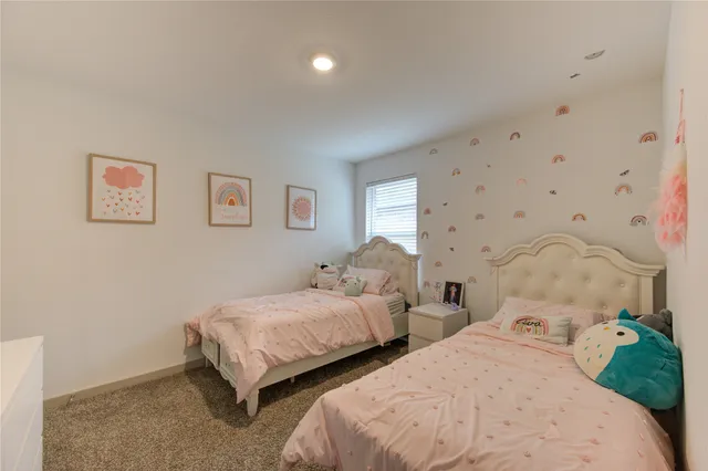 a bedroom with two beds and painting on the wall