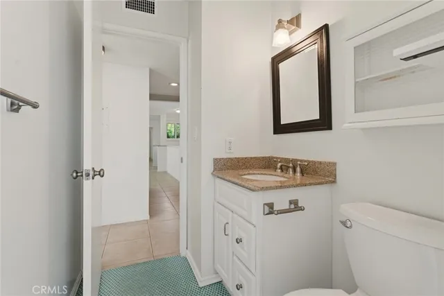 a bathroom with a granite countertop sink and a mirror