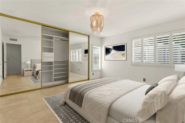 a bedroom with a bed and a chandelier