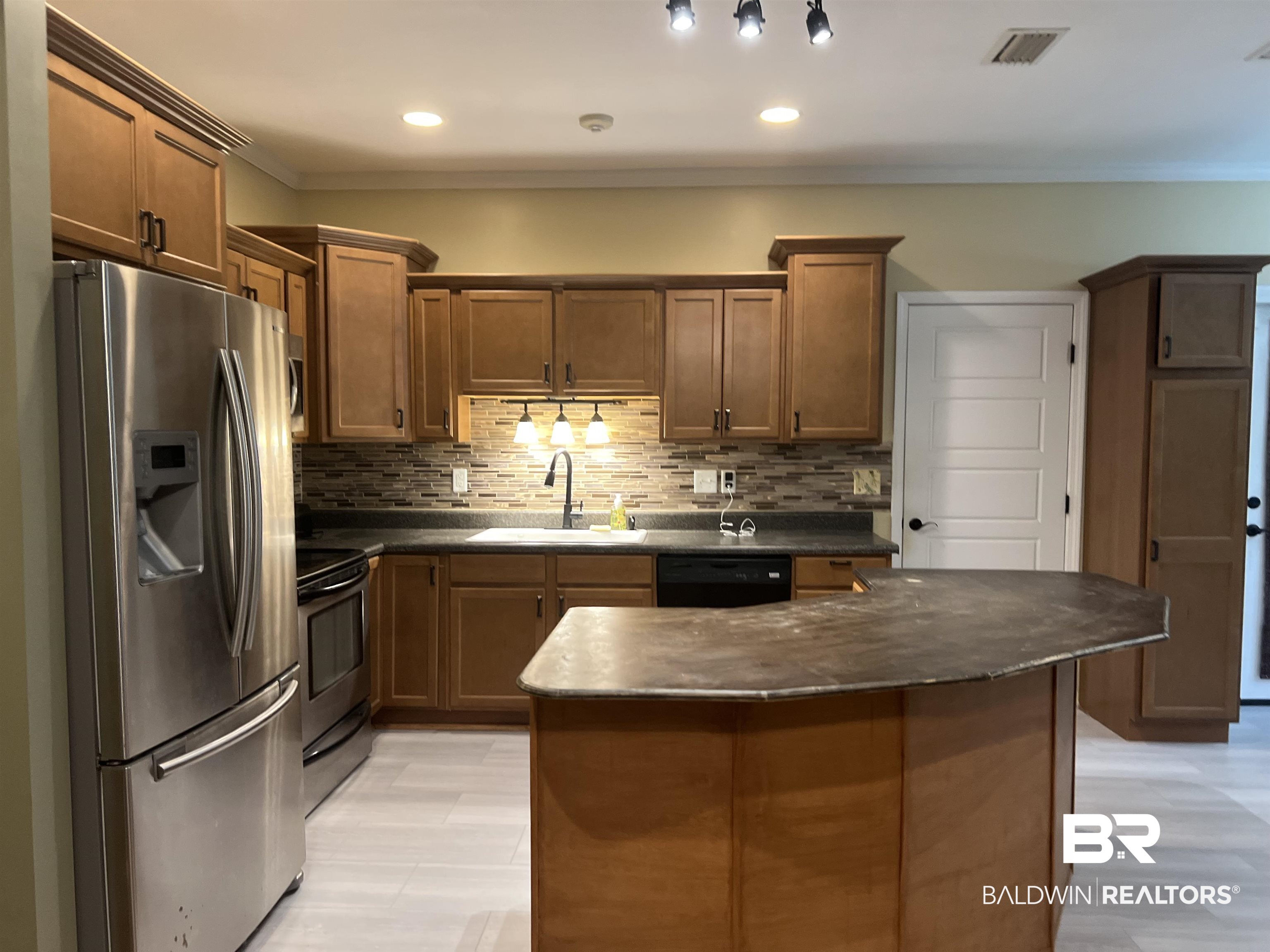 102 Brown Road Evergreen, AL 36401 - Photo 7 of 26 Kitchen with stainless steel appliances, dark countertops, backsplash, ornamental molding, and a kitchen island