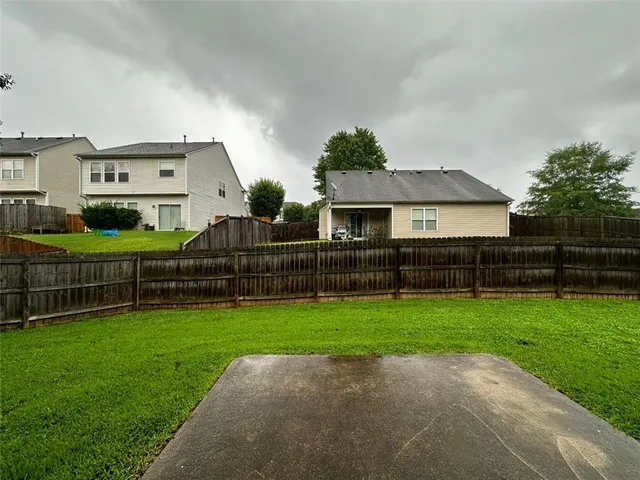a view of a house with a yard and sitting area