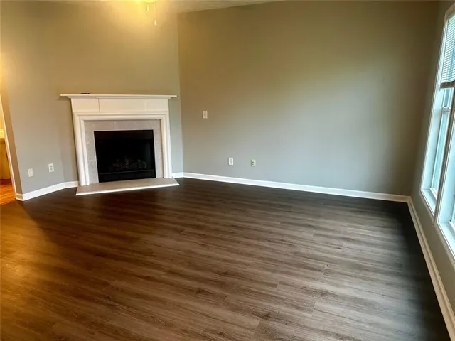 a view of empty room with wooden floor and fireplace