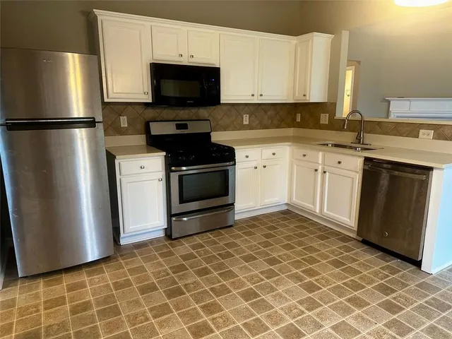 a kitchen with stainless steel appliances granite countertop a refrigerator stove and sink