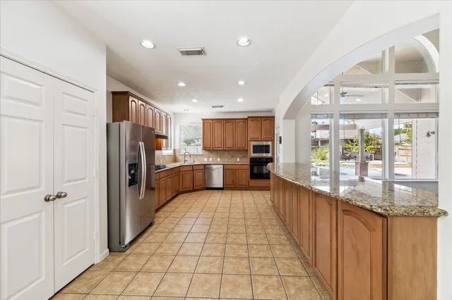 a kitchen with stainless steel appliances granite countertop a refrigerator and a sink