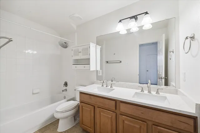 an empty room with a chandelier fan and windows