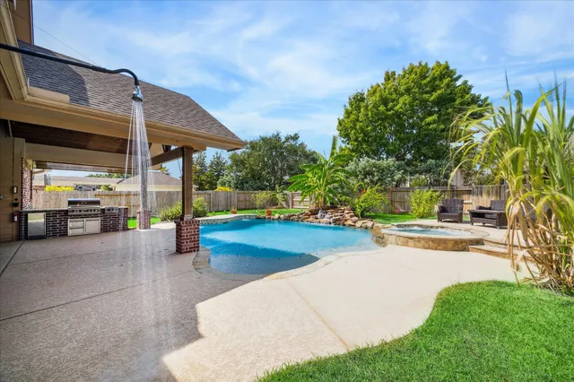 a view of a patio with a table and chairs under an umbrella