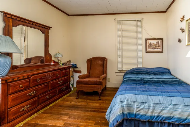 a bedroom with a bed and wooden floor