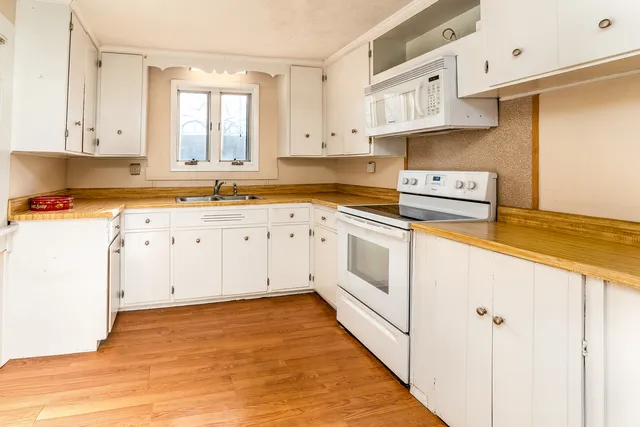 a kitchen with white cabinets and white appliances