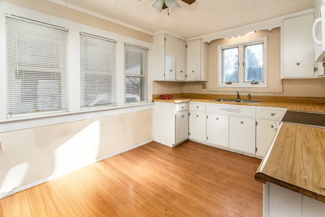 a kitchen with a sink wooden floor and a window