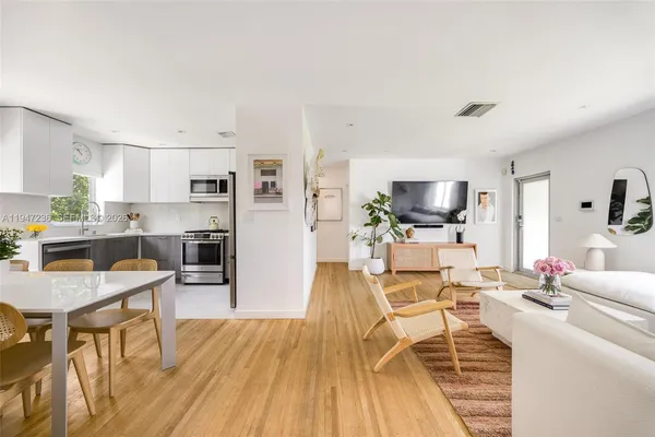a living room with furniture a flat screen tv and kitchen view