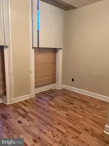 an empty room with wooden floor and cabinet