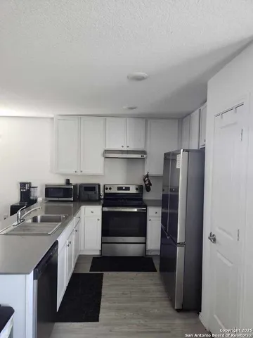 a kitchen with stainless steel appliances granite countertop a stove a refrigerator and a sink