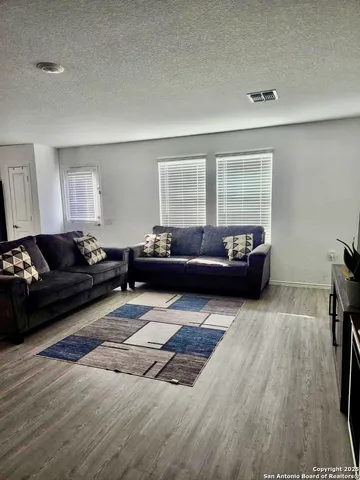 a living room with furniture and a wooden floor
