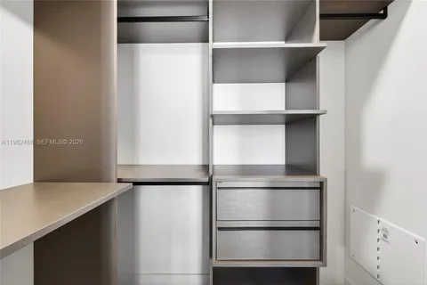 a view of walk in closet with empty racks