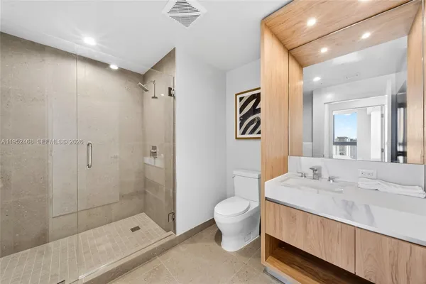 a bathroom with a sink a toilet and shower