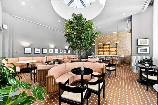 a living room with lots of furniture and a potted plant