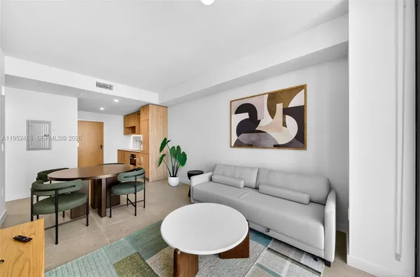 a living room with furniture a rug and a wall painting