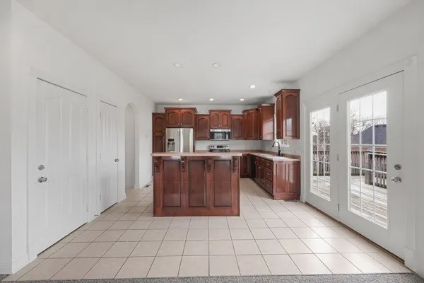 a kitchen with stainless steel appliances a sink a stove a refrigerator and cabinets