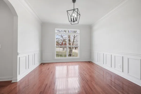 a view of a room with wooden floor chandelier and entryway