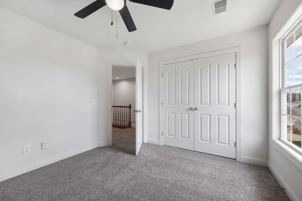 an empty room with a window and a fan