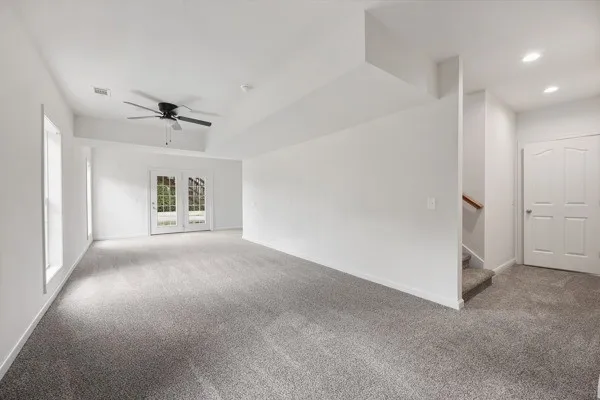 a view of an empty room with a chandelier fan