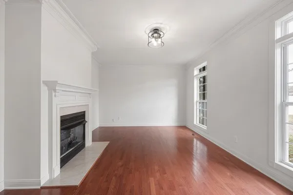 a view of a livingroom with wooden floor and a fireplace