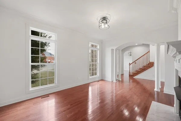 a view of a big room with windows and chandelier fan