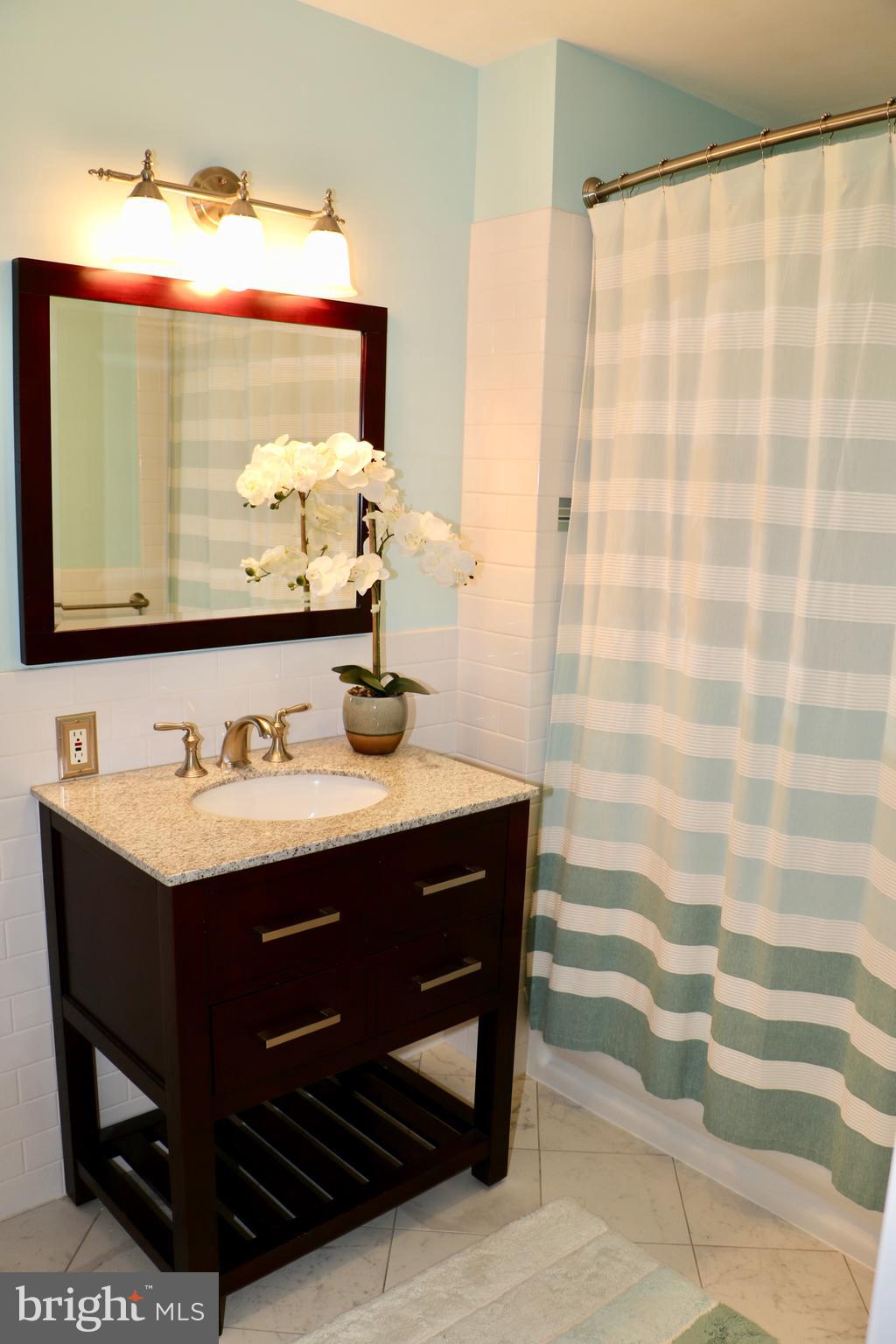 2307 Silverside Road Wilmington, DE 19810 - Photo 17 of 40 a bathroom with a sink and a mirror