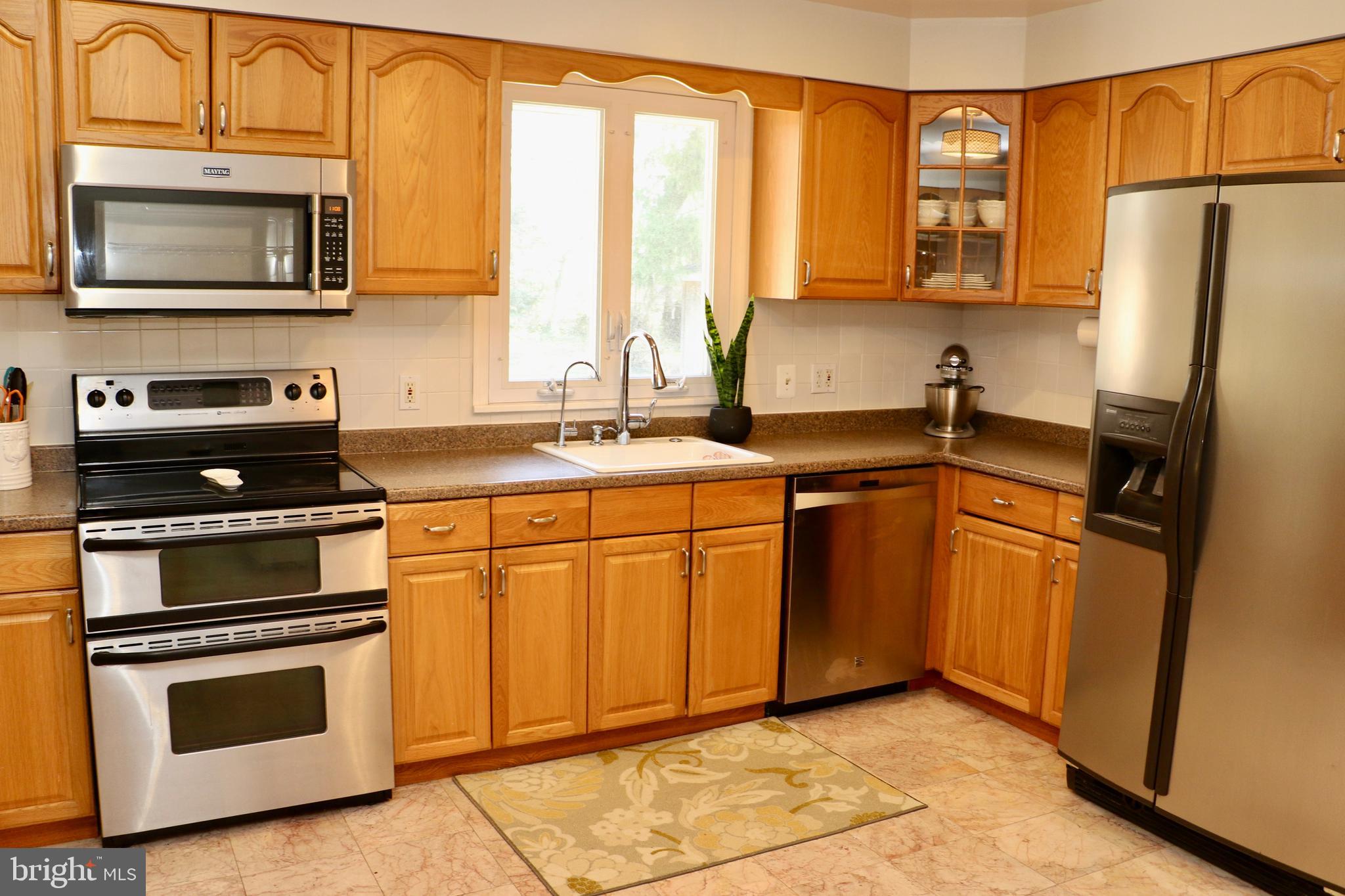 2307 Silverside Road Wilmington, DE 19810 - Photo 3 of 40 a kitchen with granite countertop a stove top oven microwave and refrigerator