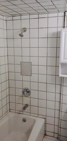 a view of an empty room with window and chandelier fan