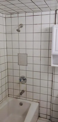 a view of an empty room with window and chandelier fan