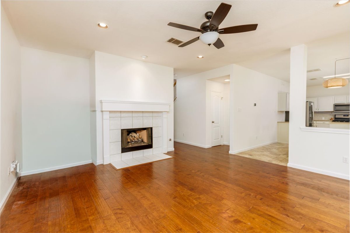 7136 Ridge Oak Road Austin, TX 78749 - Photo 8 of 28 A well-appointed family room with warm hardwood flooring and a classic tile fireplace.
