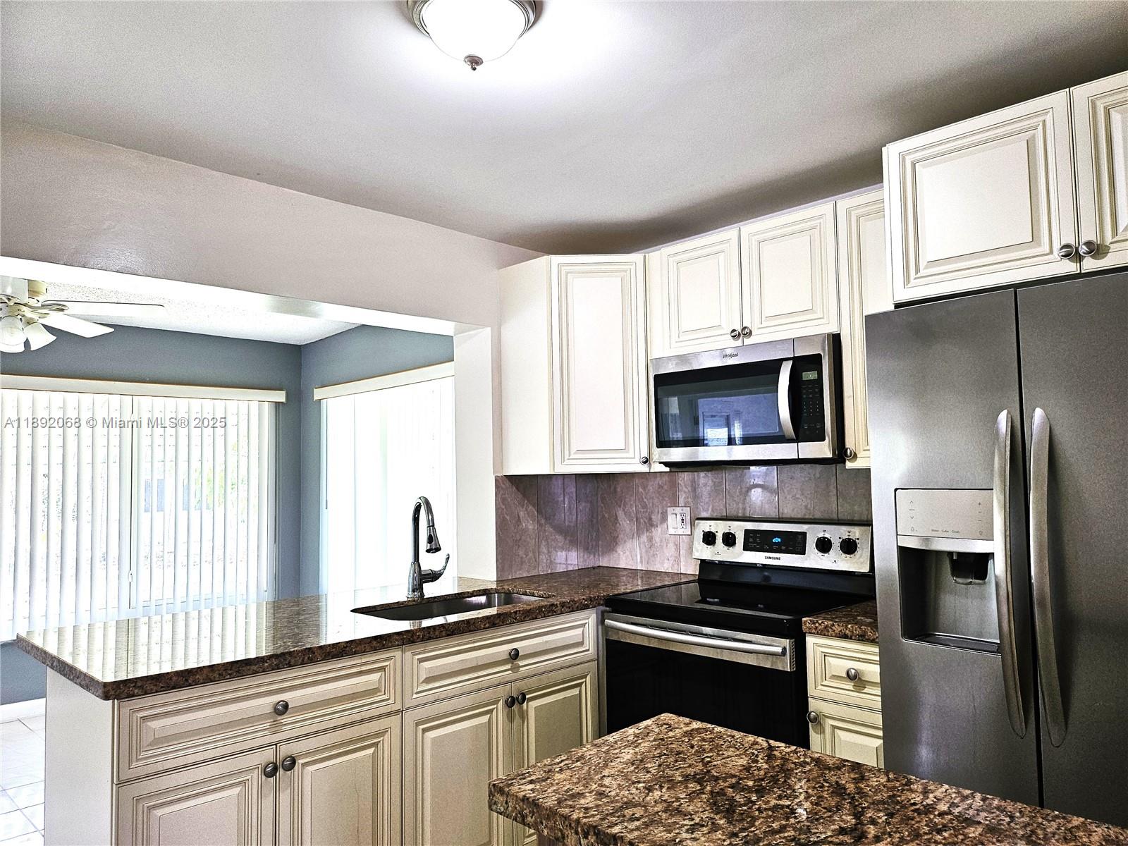 1040 Northwest 73rd Terrace Margate, FL 33063 - Photo 1 of 41 a kitchen with stainless steel appliances granite countertop a sink stove microwave and refrigerator